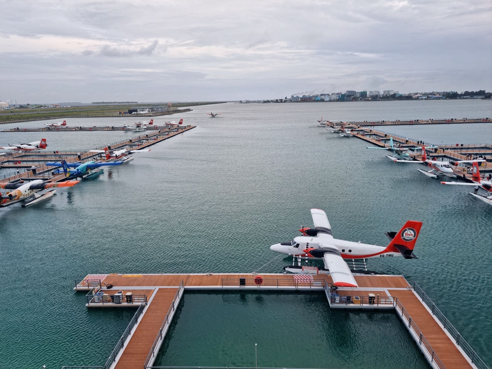 A small seaplane resting on a calm lagoon surrounded by mangroves
