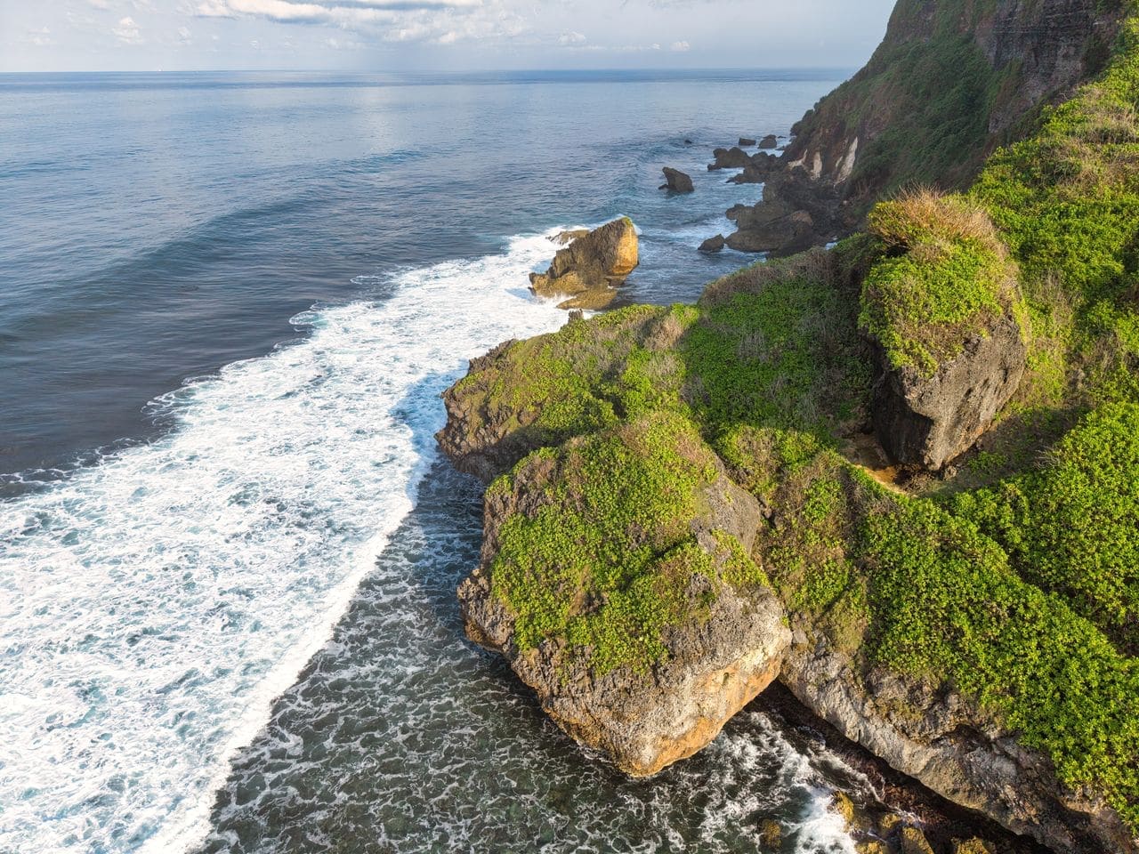 Steep cliffs dropping to the sea on a remote island at sunrise